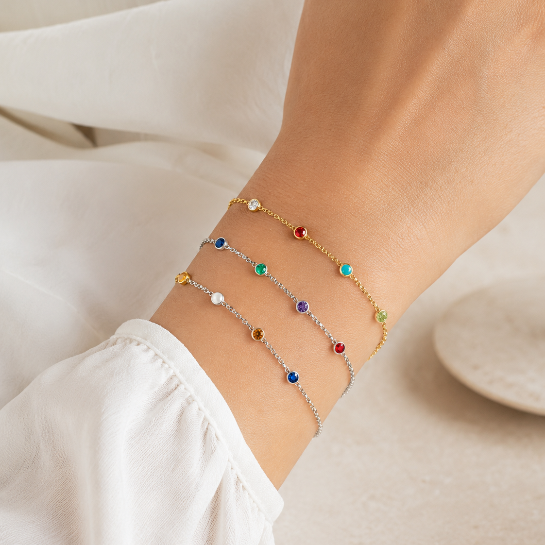 model arm showing three birthstone bracelets layered.